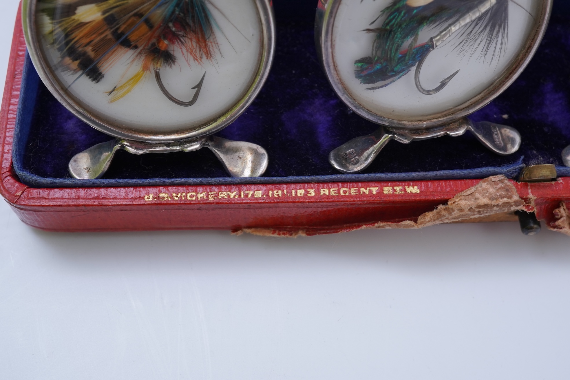 A set of four early 20th century silver mounted fishing related novelty menu holders, by Grey & Co, housed in a red leather case with gilt initials RV
